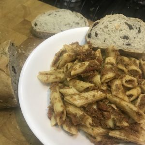 A bowl of vegan sausage tomato sauce covered penne pasta