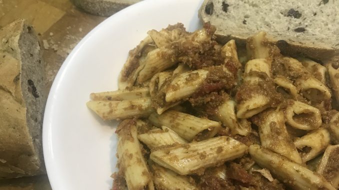 A bowl of vegan sausage tomato sauce covered penne pasta